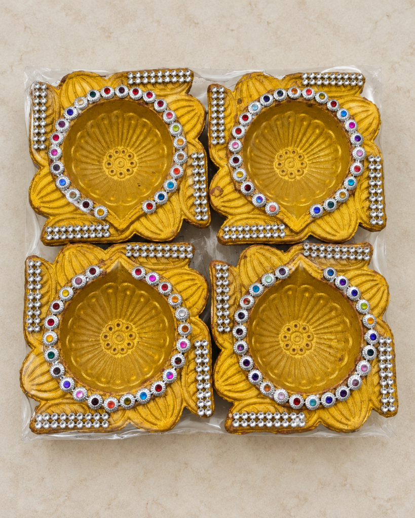 Four golden stone-work diyas