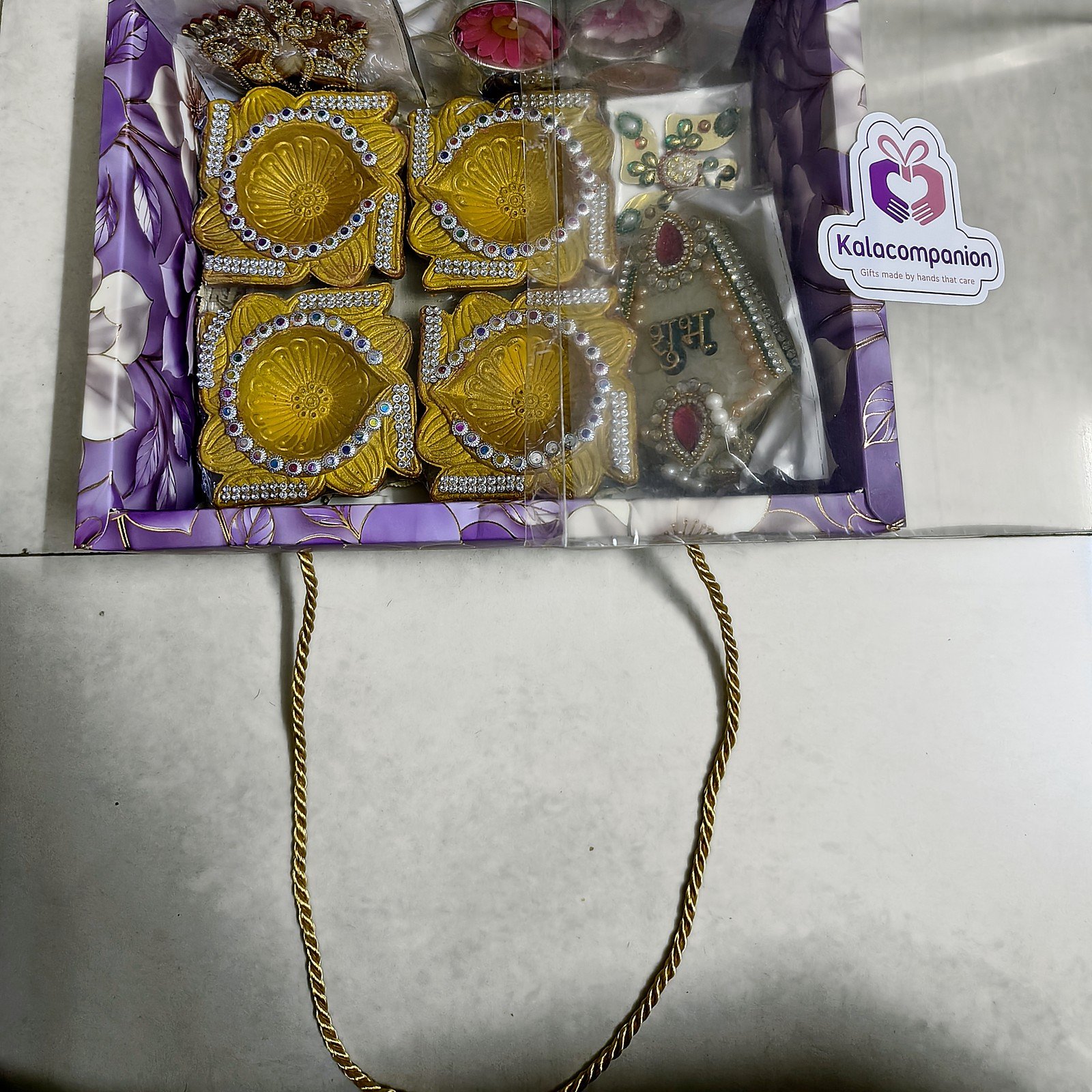 Swarna Tarang Golden Diya Hamper: packed in the floral gift box